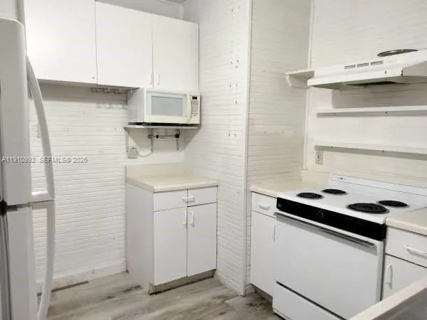 a kitchen with a cabinets and white appliances
