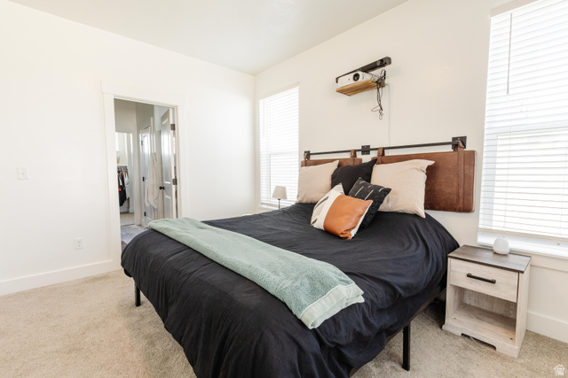 349 West 3085 South Logan, UT 84321 - Photo 13 of 37 Carpeted bedroom featuring white walls, white trim, and two windows with horizontal blinds