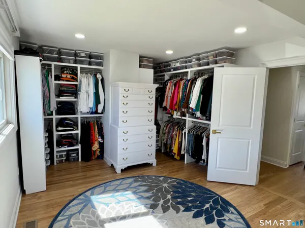 a view of walk in closet with clothes and shoes