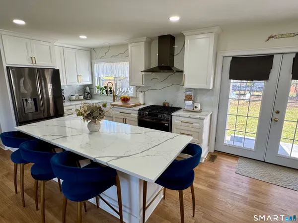 a kitchen with a refrigerator a stove a sink dishwasher with a dining table and chairs