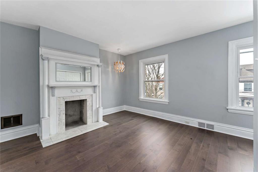 2002 Hampton Street Pittsburgh, PA 15218 - Photo 13 of 21 an empty room with wooden floor fireplace and windows