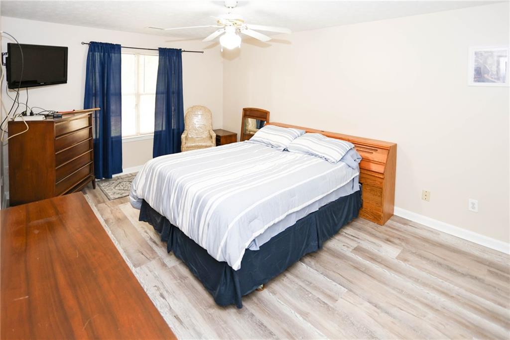 661 Michael Circle Monroe, GA 30655 - Photo 8 of 20 a spacious bedroom with a bed and a flat screen tv