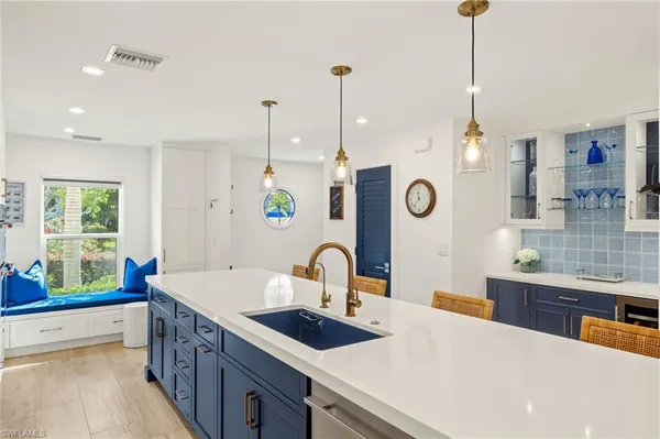 a kitchen with kitchen island a sink appliances and a counter top space
