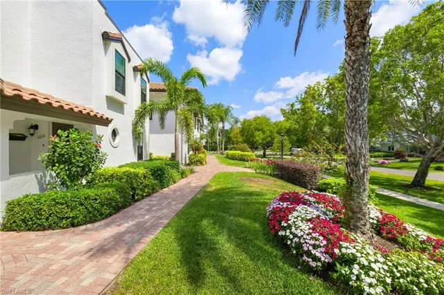 a green field with flowers and trees