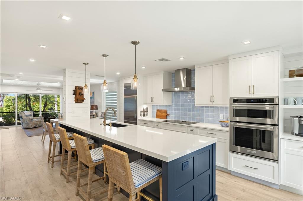 1060 6th Street South, Unit 1060 Naples, FL 34102 - Photo 7 of 26 a kitchen with a table chairs sink and cabinets