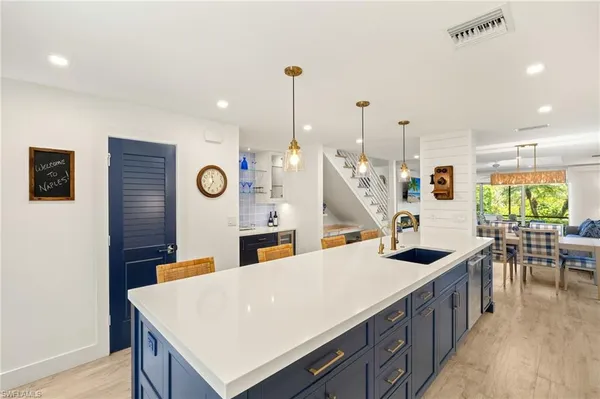 a kitchen with stainless steel appliances granite countertop a sink a stove and a wooden floors