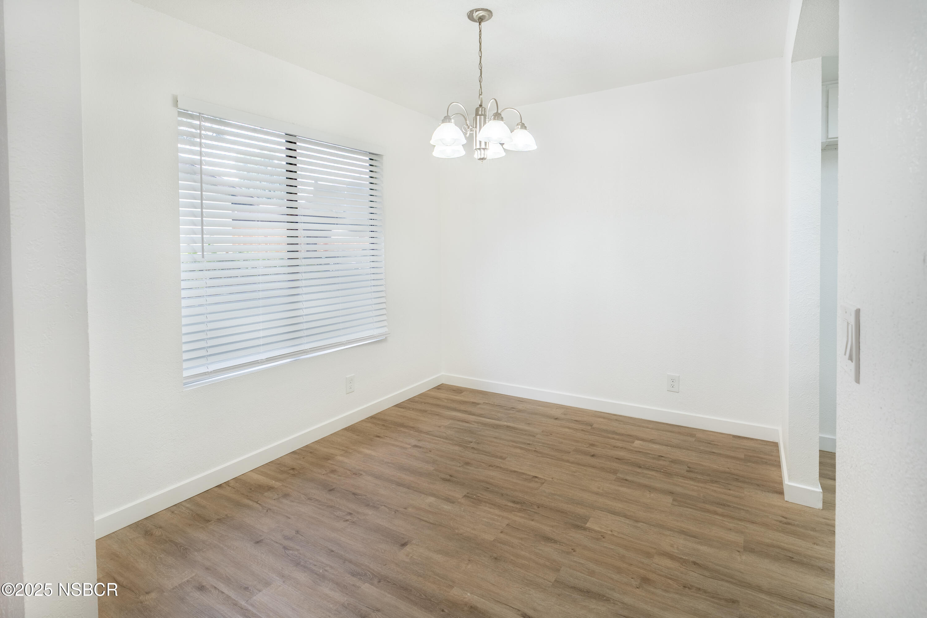 1200 East Walnut Avenue, Unit A Lompoc, CA 93436 - Photo 9 of 23 a view of an empty room with wooden floor and a window