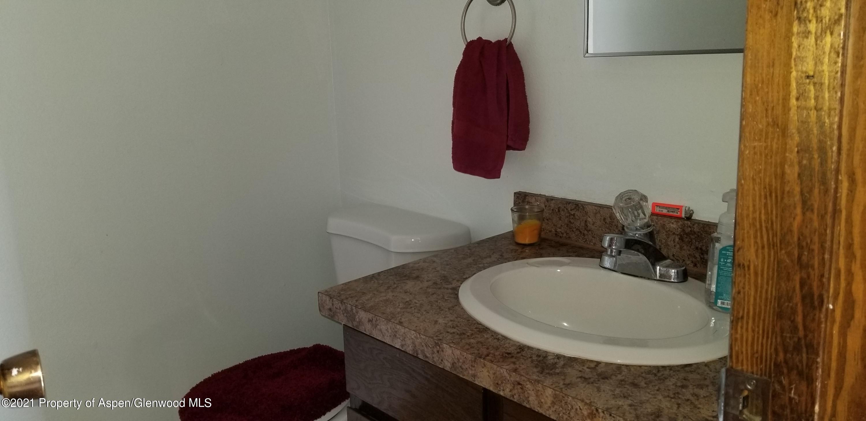 1179 Park Avenue Rifle, CO 81650 - Photo 4 of 16 a bathroom with a granite countertop sink and a mirror