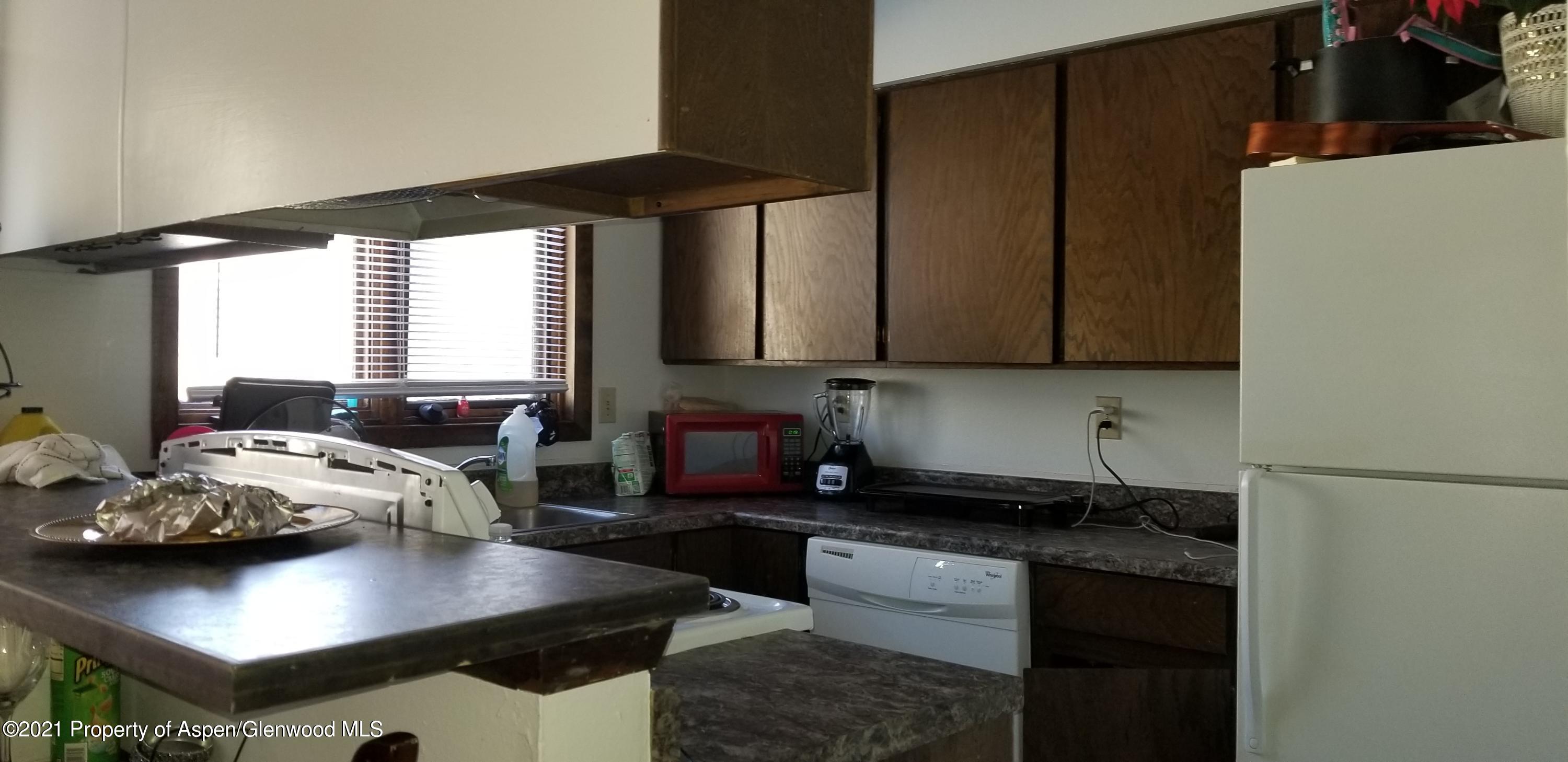 1179 Park Avenue Rifle, CO 81650 - Photo 9 of 16 a kitchen with stainless steel appliances a sink a stove a refrigerator and cabinets