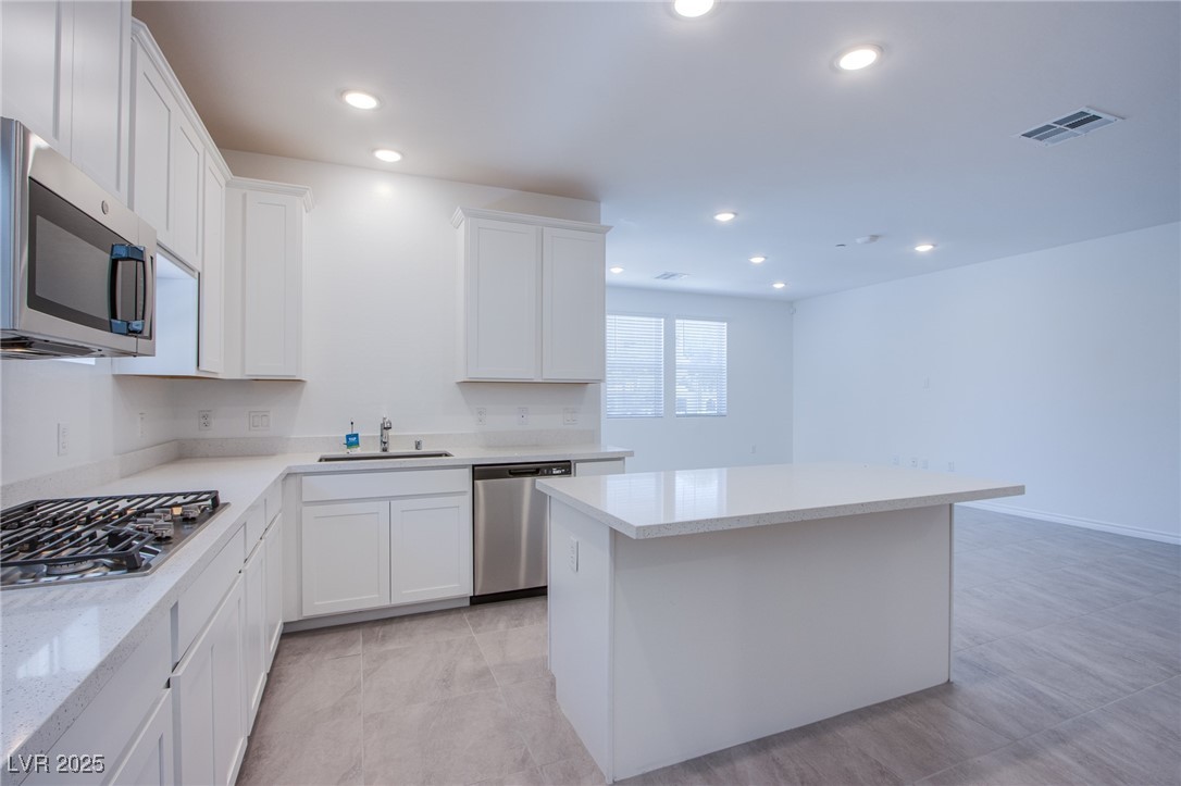 2555 Hampton Road, Unit 11201 Henderson, NV 89052 - Photo 5 of 36 Kitchen with appliances with stainless steel finishes, a center island, white cabinets, recessed lighting, and light stone counters