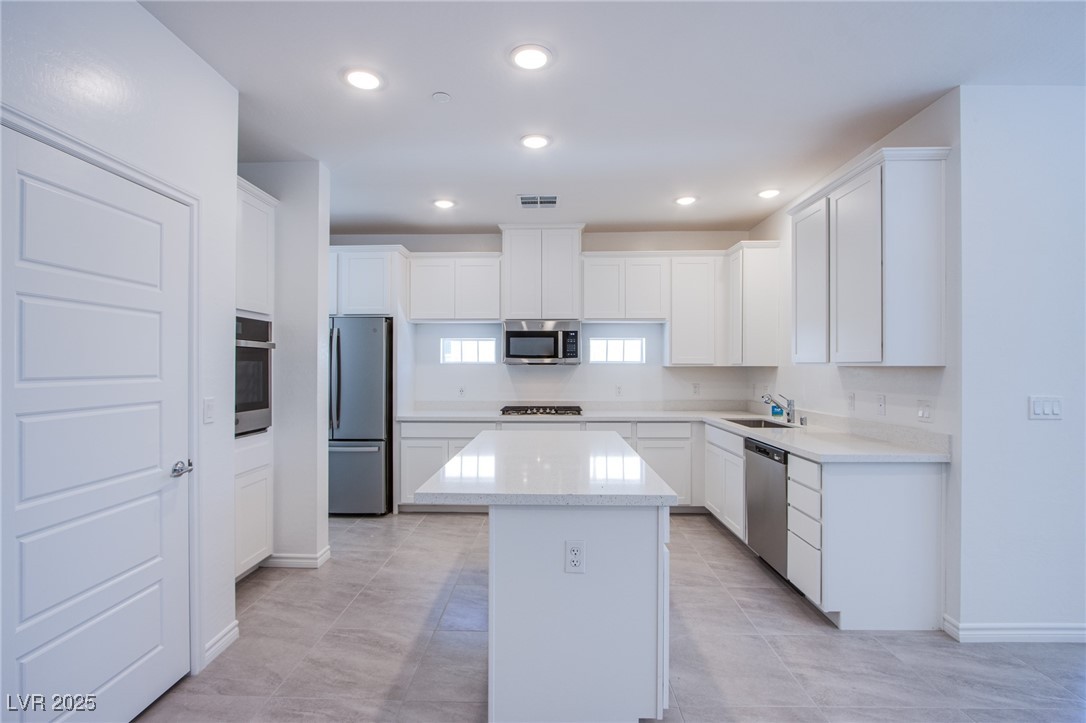2555 Hampton Road, Unit 11201 Henderson, NV 89052 - Photo 7 of 36 Kitchen with appliances with stainless steel finishes, a center island, white cabinets, recessed lighting, and light tile patterned floors
