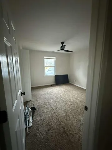 en empty room with windows and ceiling fan view