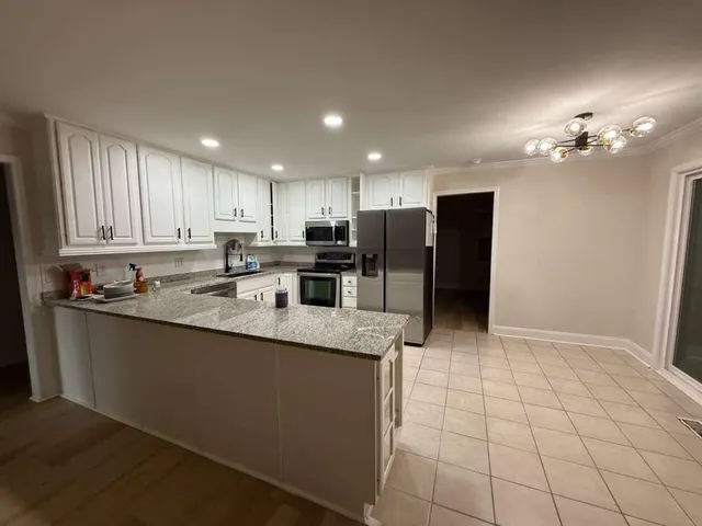 a kitchen with stainless steel appliances granite countertop a refrigerator a sink a stove a microwave and island