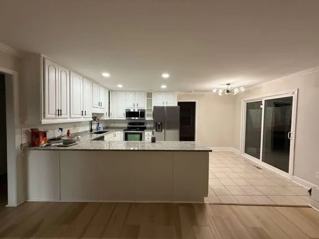 a kitchen with stainless steel appliances granite countertop a sink a stove and a refrigerator