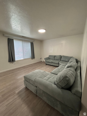 203 North Geneva Road, Unit 10 Provo, UT 84601 - Photo 2 of 16 Living area featuring wood-finish flooring, a window with horizontal blinds, and a flush-mount ceiling light