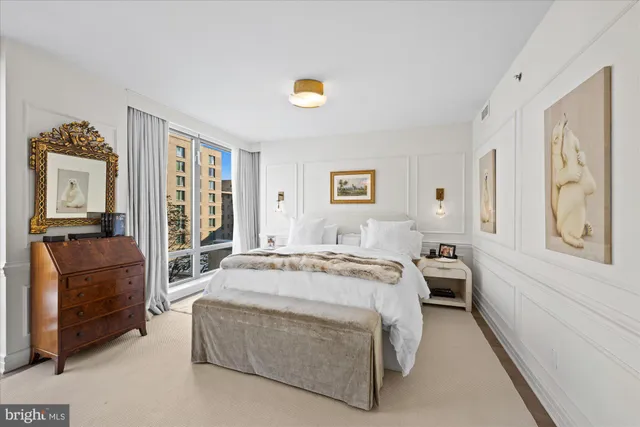 a spacious bedroom with a bed a couch and dresser