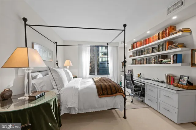 a bedroom with a bed a lamp and a closet