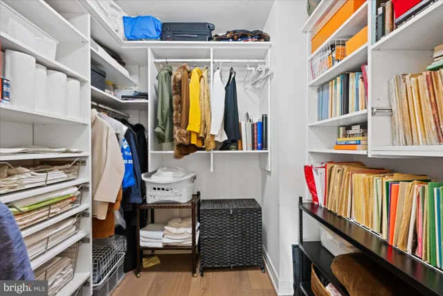 a view of walk in closet with clothes and shoes
