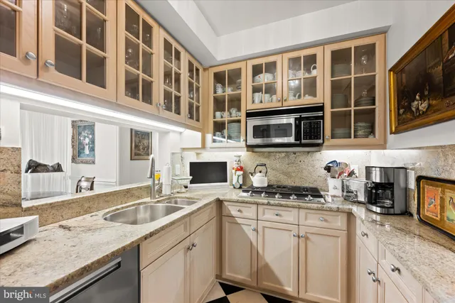 a kitchen with stainless steel appliances granite countertop a sink and a stove
