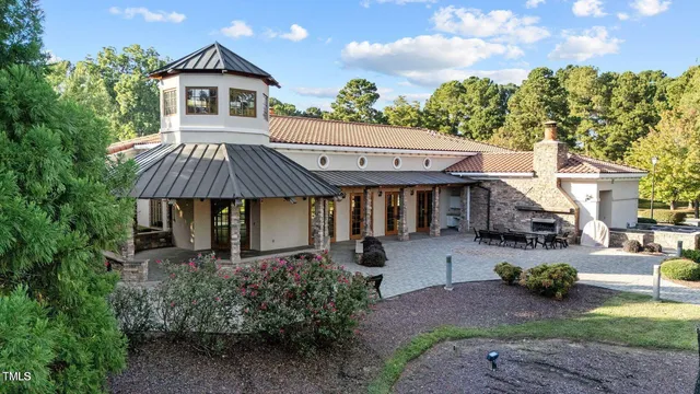 a view of a patio with table and chairs with plants and trees
