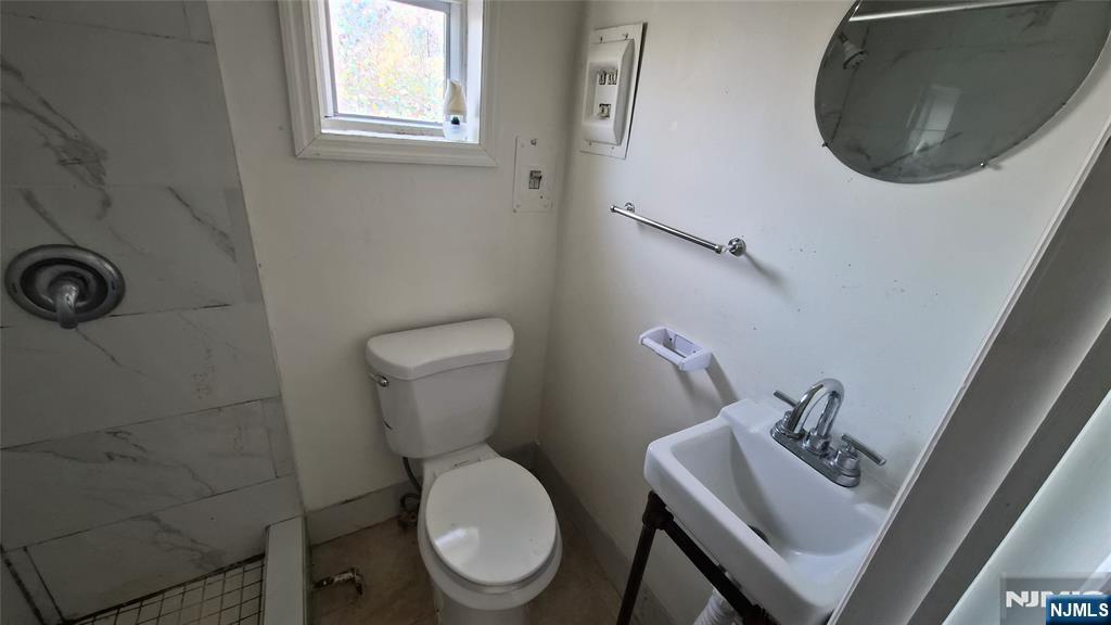 309 Hudson Street Hackensack, NJ 07601 - Photo 6 of 6 a white toilet sitting next to a bathroom sink