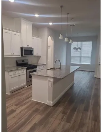 a kitchen with granite countertop a stove and a sink
