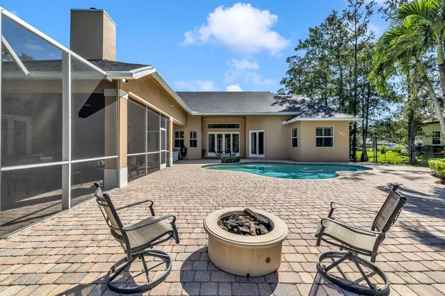 a view of a house with backyard and sitting area