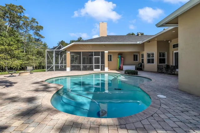 a view of a house with swimming pool and sitting area
