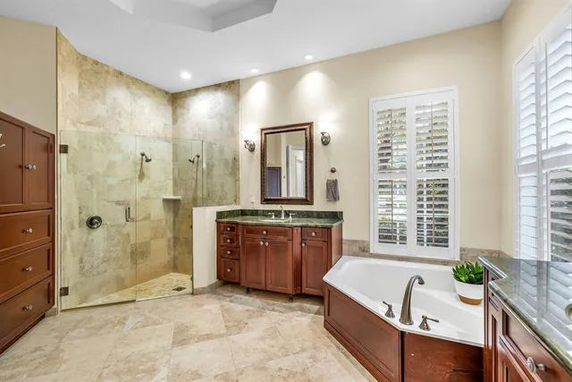 a spacious bathroom with a granite countertop tub sink and a shower