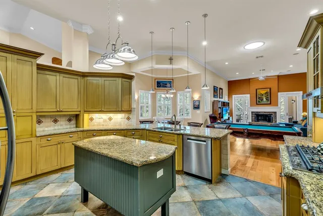 a kitchen with stainless steel appliances granite countertop a sink a stove and a refrigerator