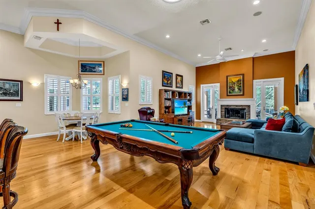 a living room with furniture pool table and a fireplace