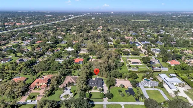 an aerial view of residential houses with outdoor space and trees
