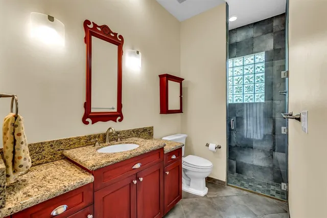 a bathroom with a granite countertop sink toilet and shower