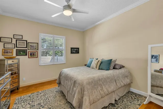 a bedroom with a bed and dresser with floor to ceiling window