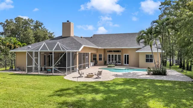 a view of a house with a backyard and a tree