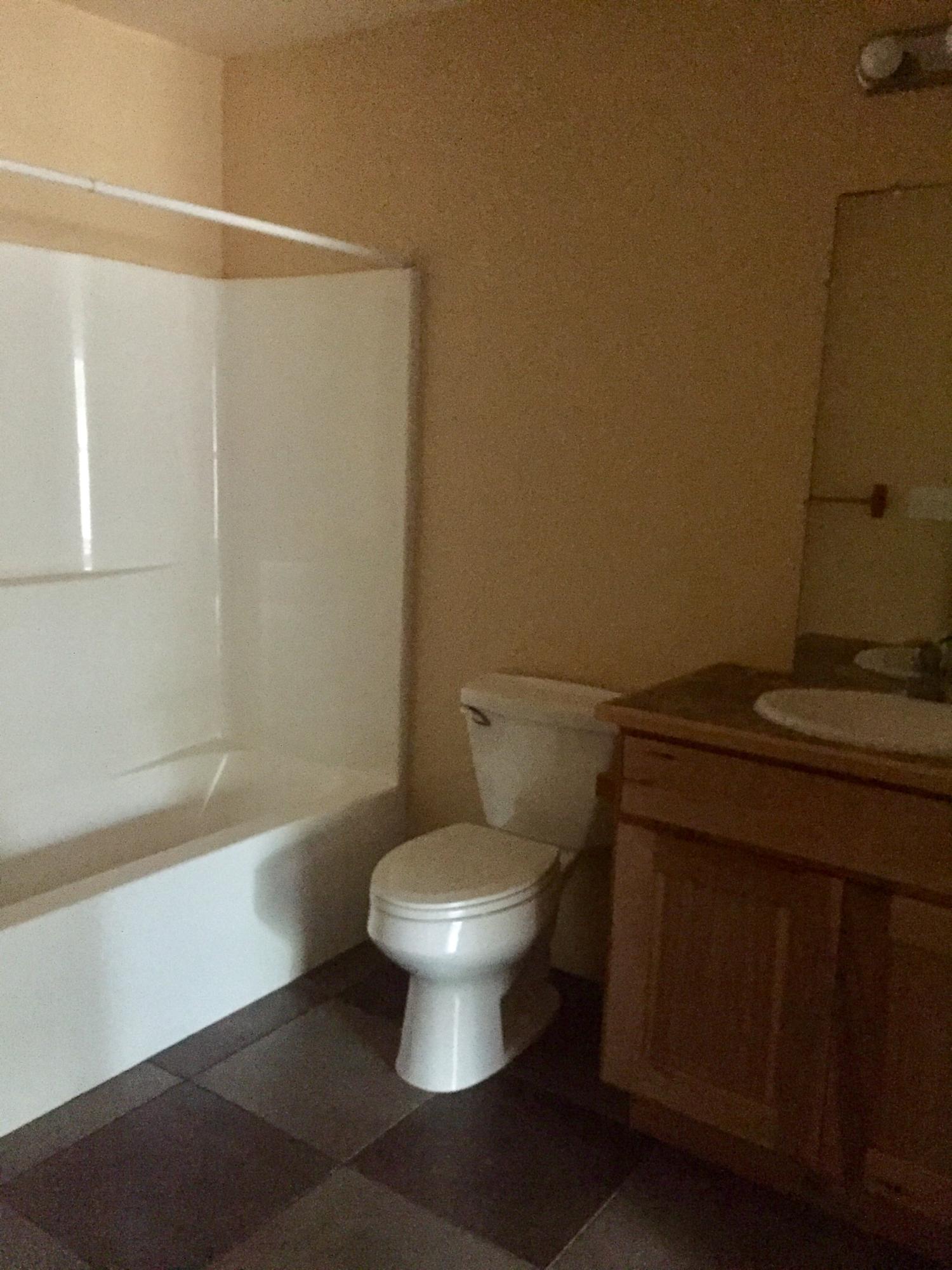 5960 Old Hickory Road Crestview, FL 32539 - Photo 15 of 43 a white toilet sitting next to a bathroom sink and a shower