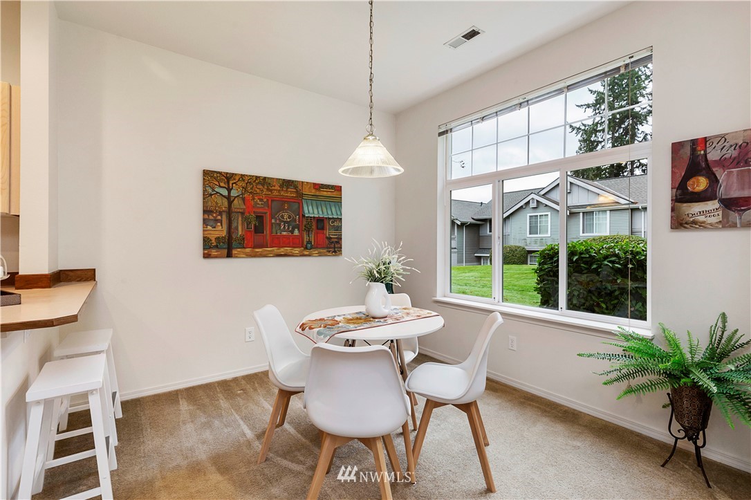 22611 4th Avenue West, Unit 104 Bothell, WA 98021 - Photo 8 of 24 a dining room with furniture a floor to ceiling window and potted plants