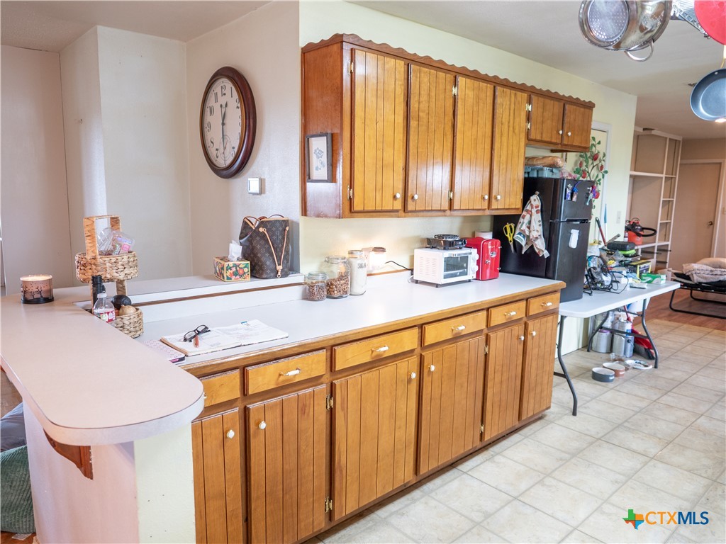 6611 Tigre Road Beeville, TX 78102 - Photo 12 of 31 a kitchen with a sink and a clock on the wall