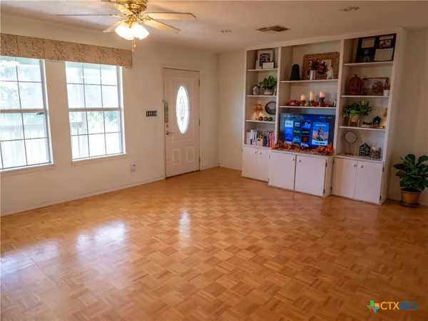 an empty room with windows and cabinet