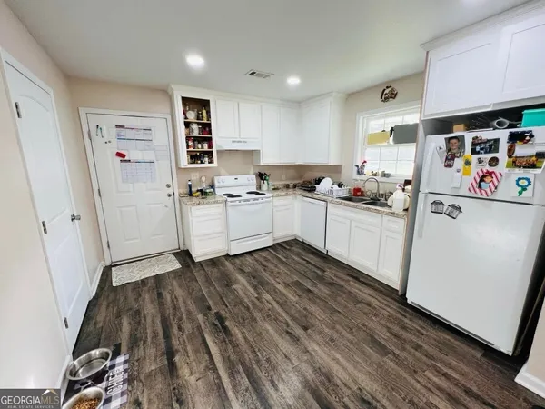 a kitchen with a refrigerator and a stove top oven