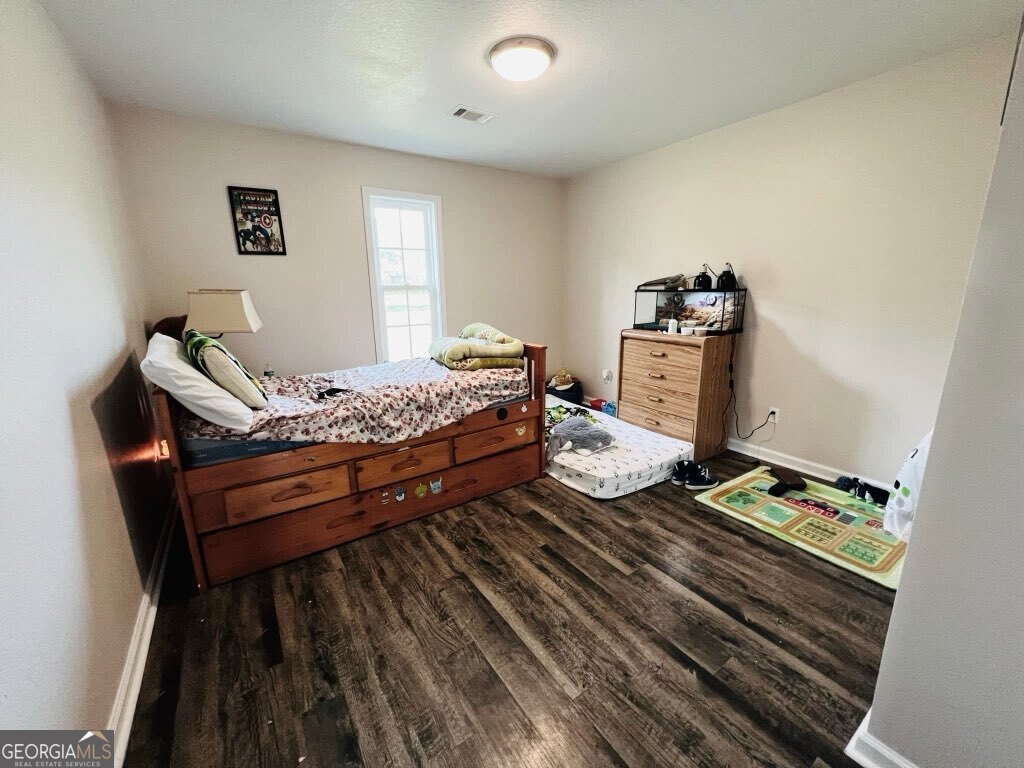 75 Gov Seay Road Collins, GA 30421 - Photo 5 of 7 a bedroom with a bed and wooden floor