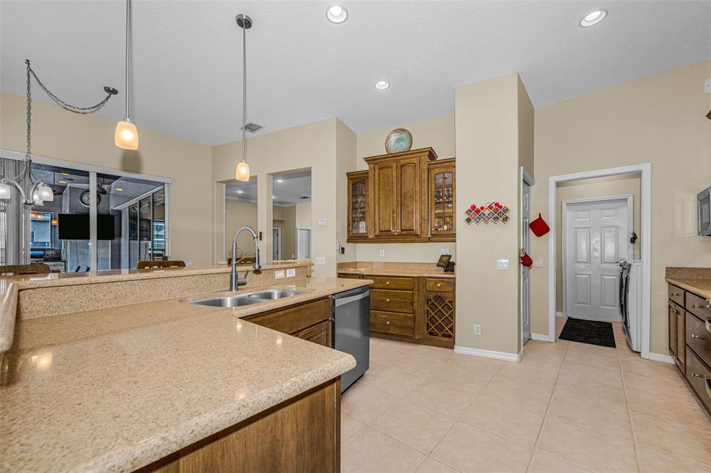 1151 Arlinbrook Drive Trinity, FL 34655 - Photo 30 of 69 a large kitchen with kitchen island a stove a sink dishwasher and a refrigerator with wooden floor