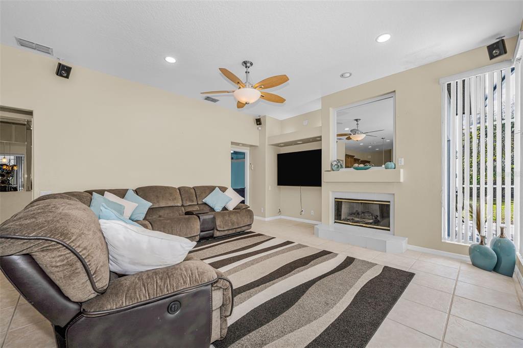 1151 Arlinbrook Drive Trinity, FL 34655 - Photo 38 of 69 a living room with furniture a flat screen tv and a fireplace