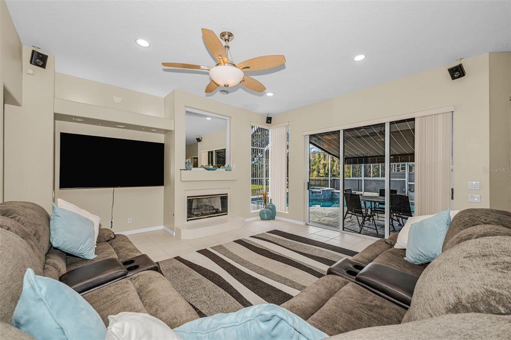 1151 Arlinbrook Drive Trinity, FL 34655 - Photo 39 of 69 a living room with furniture a fireplace and a flat screen tv