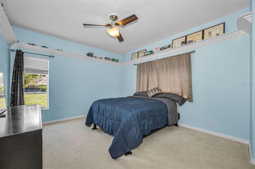 1151 Arlinbrook Drive Trinity, FL 34655 - Photo 50 of 69 a spacious bedroom with a bed and a chandelier