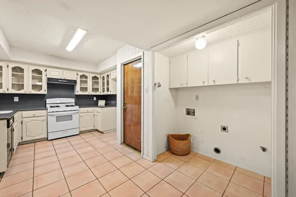 a kitchen with white cabinets and white appliances