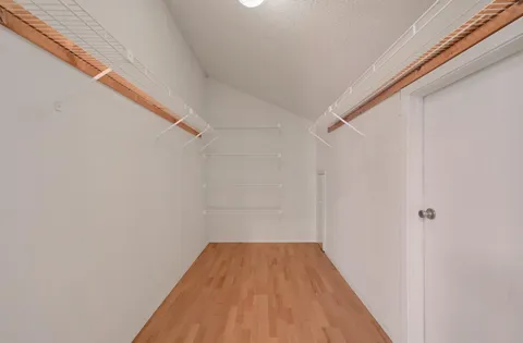 a view of a room with wooden floor and white walls