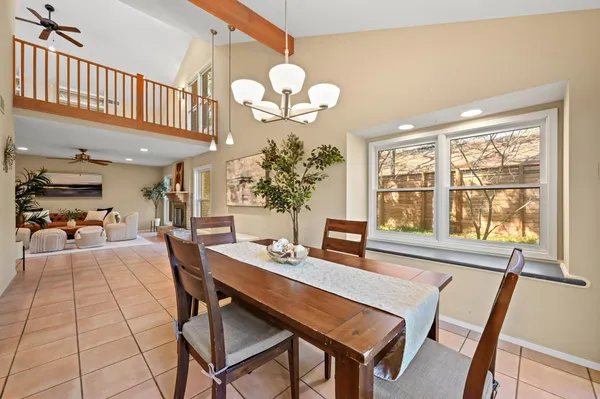 a view of a dining room with furniture a chandelier and wooden floor