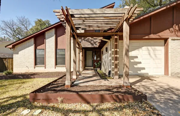 a view of a house with backyard and sitting area