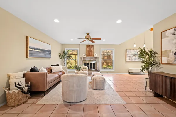 a living room with fireplace furniture and a large window